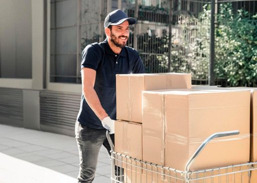 Colaborador da Garra Facilities realizando transporte seguro de caixas e equipamentos, garantindo agilidade e eficiência operacional.